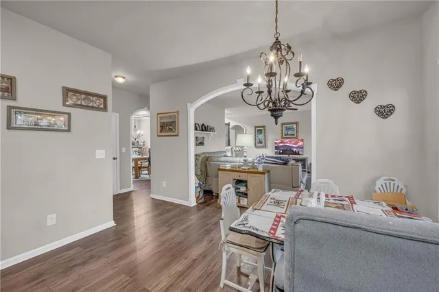 a living room with dining table and a chandelier