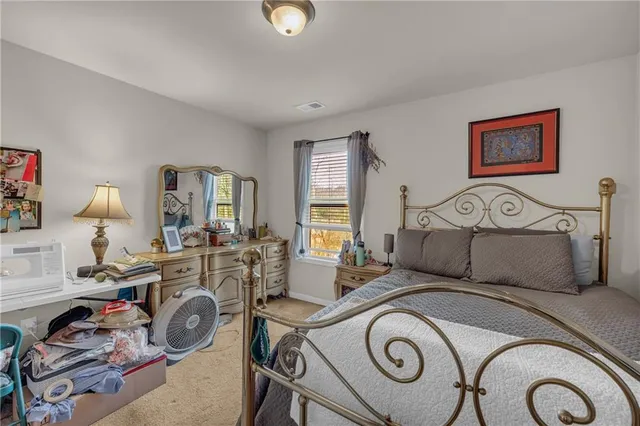 a bedroom with bed and a a mirror on dresser