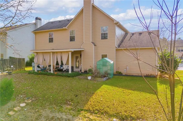 a view of a house with a yard and sitting area