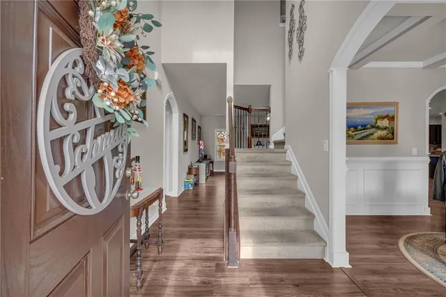 a view of a hallway with wooden floor and a chandelier