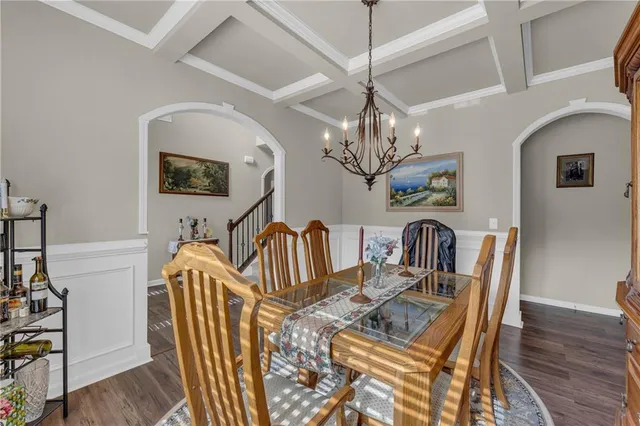 a view of a dining room with furniture a chandelier and wooden floor