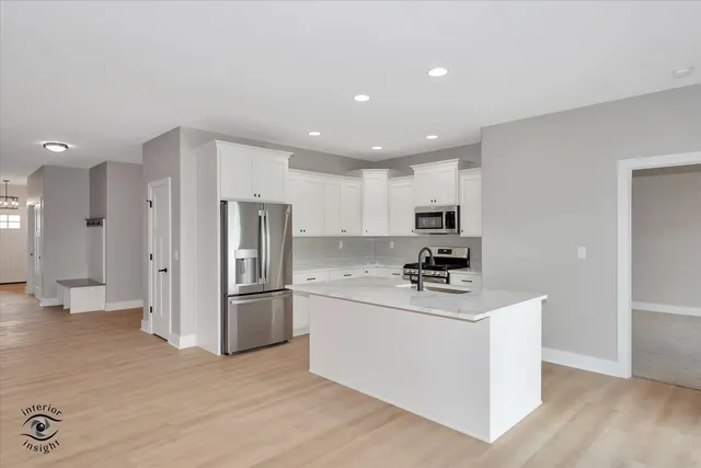 a kitchen with stainless steel appliances a refrigerator sink and microwave