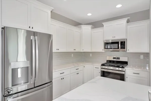 a kitchen with white cabinets and stainless steel appliances