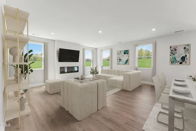 a living room with furniture a flat screen tv and a large window