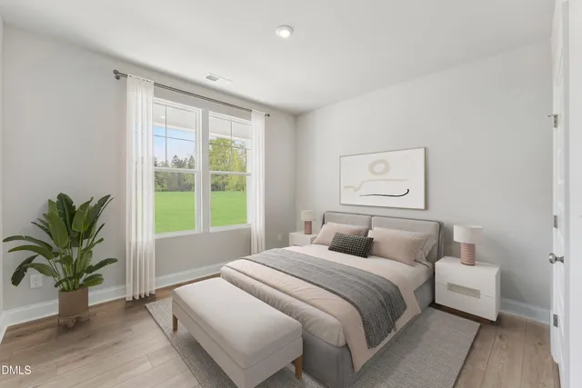 a bedroom with a large bed and a potted plant