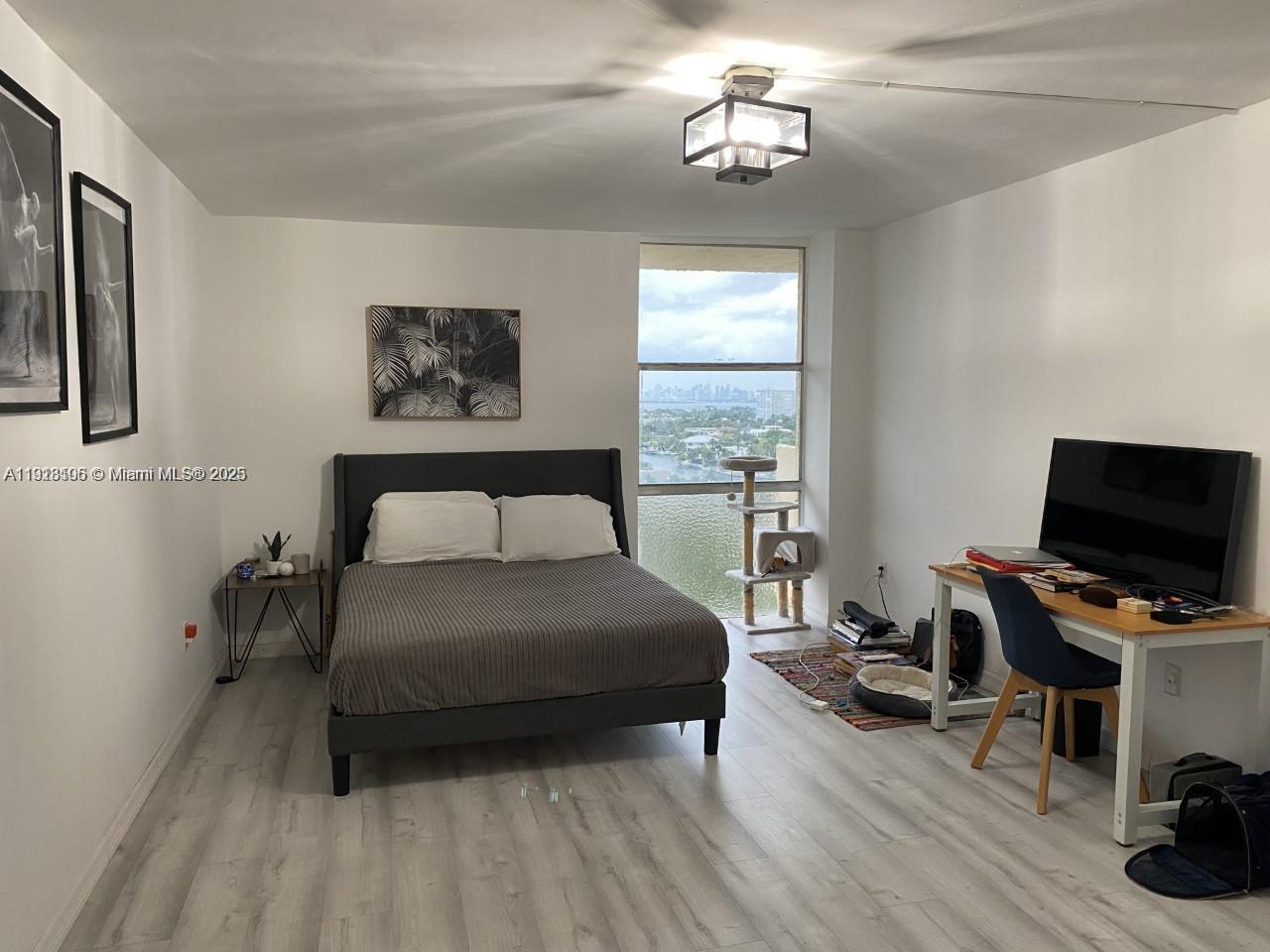 Vecino del Mar Condominium North Miami, FL 33181 - Photo 7 of 10 a bedroom with a bed and a chandelier