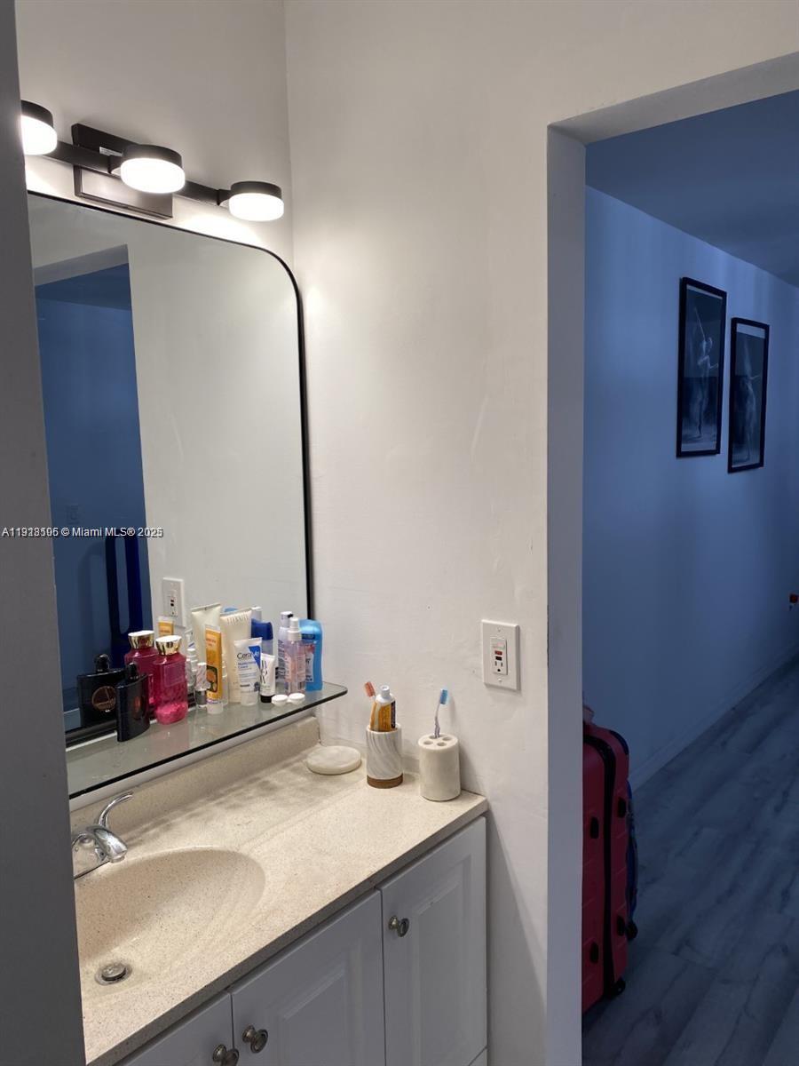 Vecino del Mar Condominium North Miami, FL 33181 - Photo 9 of 10 a bathroom with a granite countertop sink and a mirror