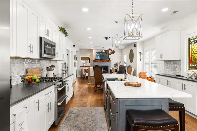 an open kitchen with a sink a center island and stainless steel appliances