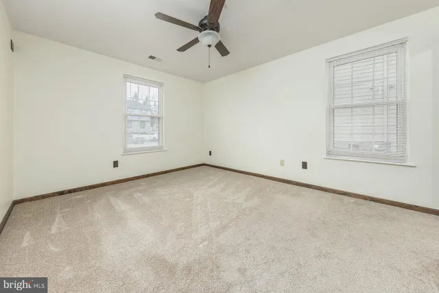 an empty room with windows and closet
