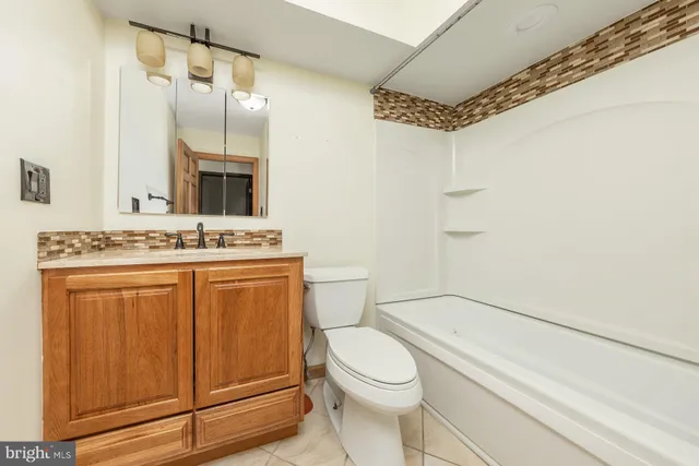 a bathroom with a granite countertop sink toilet mirror vanity and shower