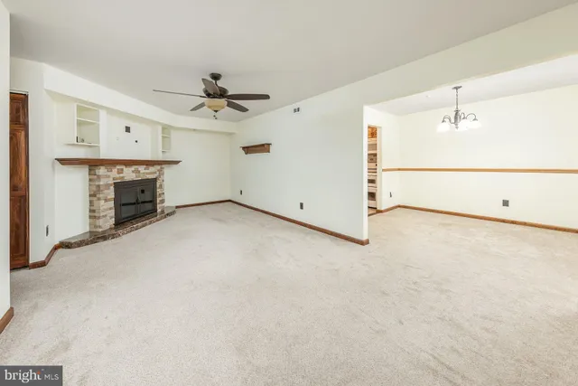 an empty room with fireplace and fan