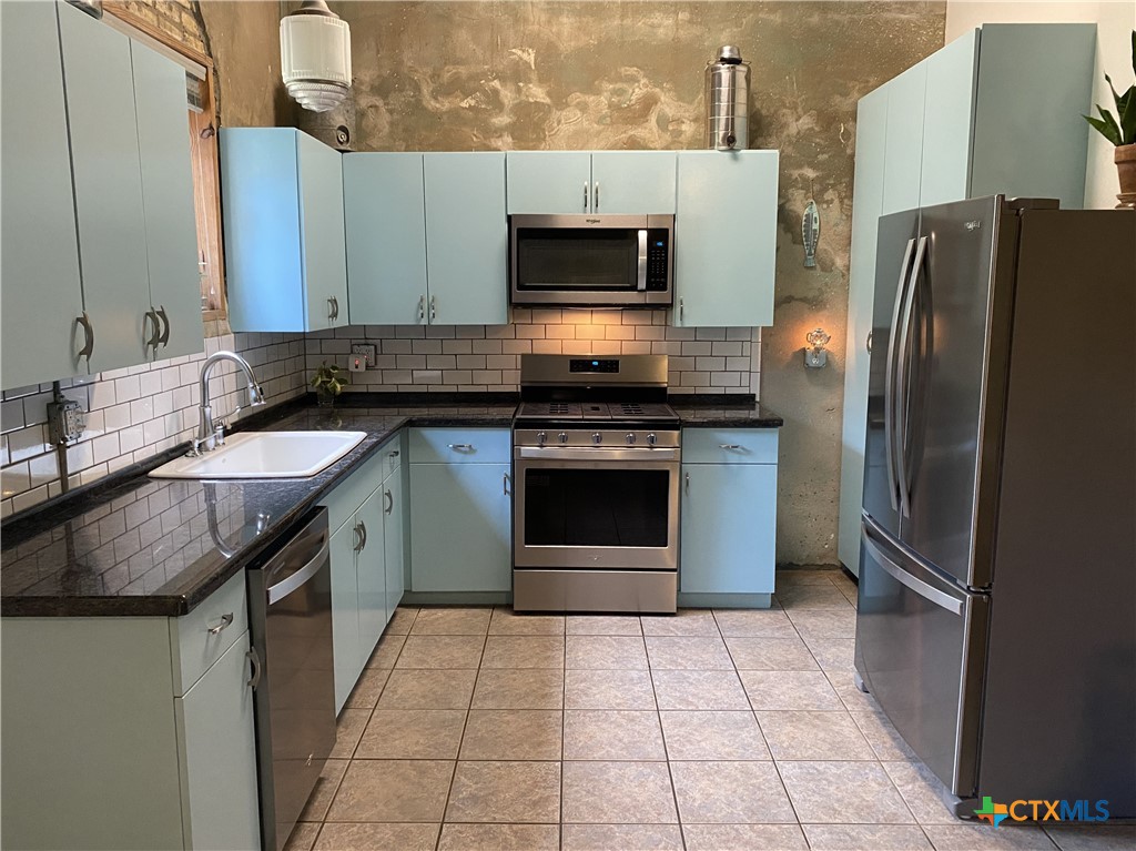 316 South Main Street Seadrift, TX 77983 - Photo 4 of 12 a kitchen with stainless steel appliances granite countertop a stove a refrigerator and a sink