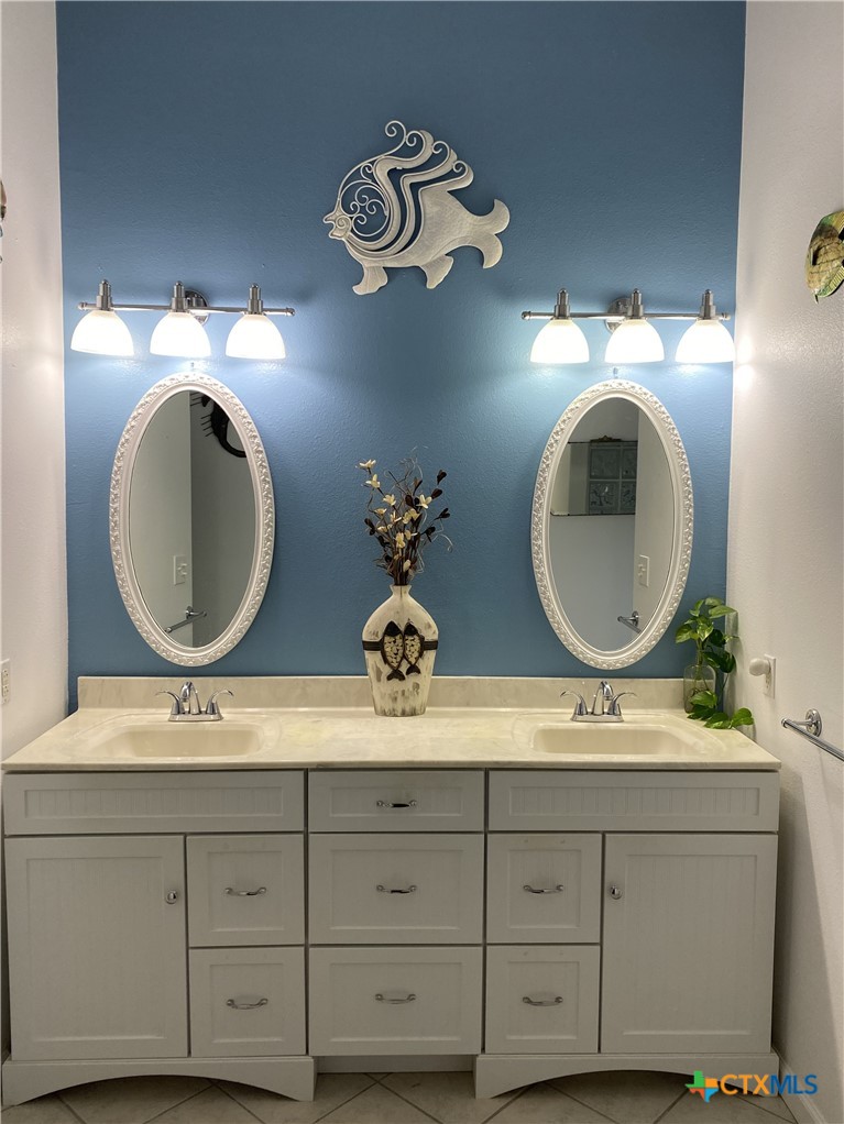 316 South Main Street Seadrift, TX 77983 - Photo 7 of 12 a bathroom with a double vanity sink and a mirror