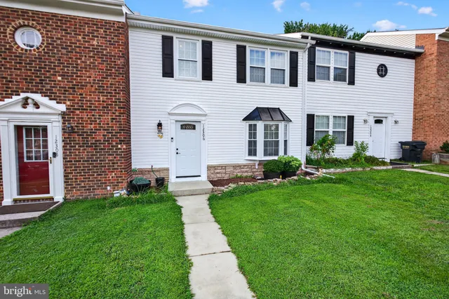 a front view of a house with a garden and plants