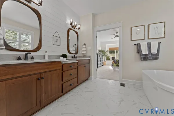 a spacious bathroom with a double vanity sink a mirror a bathtub and a shower