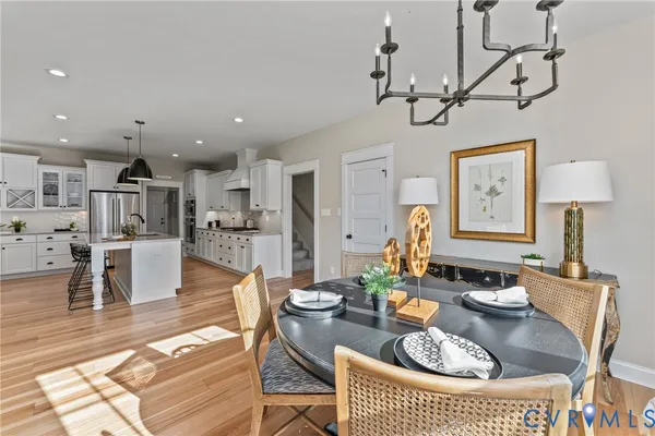a living room with furniture kitchen view and a wooden floor