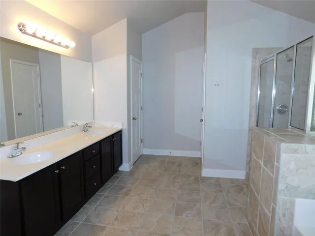a bathroom with a tub a sink and a large mirror