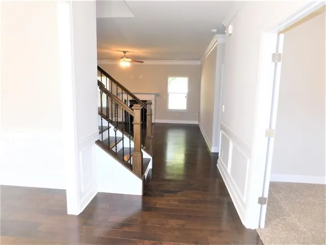 a view of a hallway with wooden floor and entryway