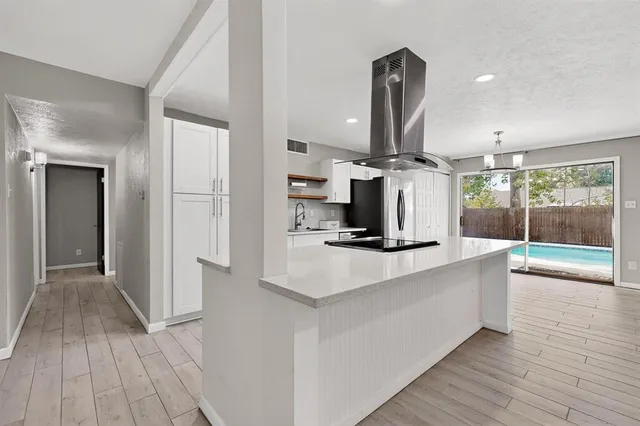 a kitchen with granite countertop a sink a counter space appliances and cabinets