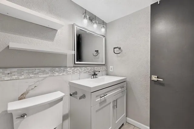 an empty room with wooden floor ceiling fan and windows