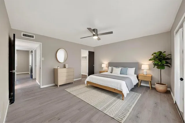 a spacious bedroom with a large bed and a chandelier