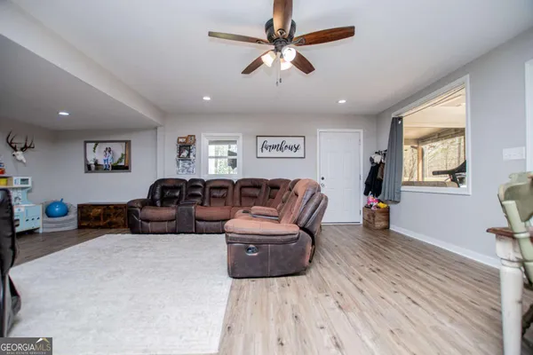 a kitchen with stainless steel appliances granite countertop a stove top oven a sink dishwasher and white cabinets with wooden floor