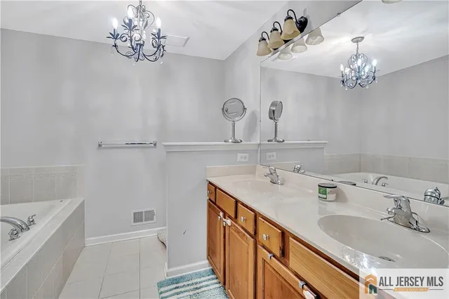 a bathroom with a tub sink and mirror