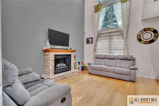 a living room with furniture a flat screen tv and a fireplace