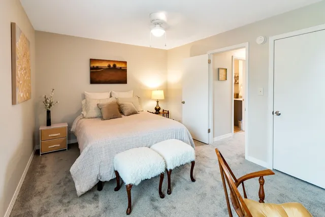 a bedroom with a bed a mirror and lamp