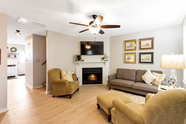 a living room with furniture a flat screen tv and a fireplace
