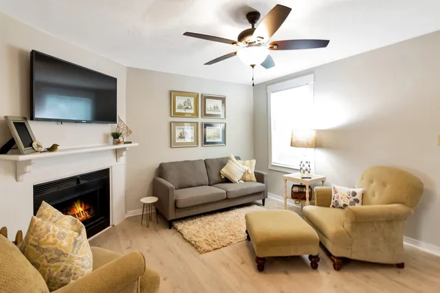 a living room with furniture a flat screen tv and a fireplace