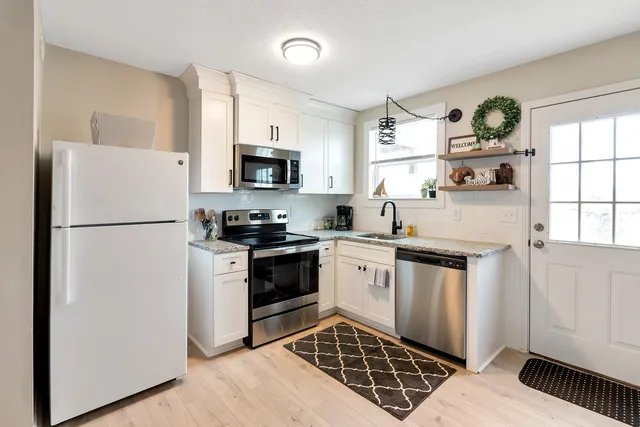 a kitchen with stainless steel appliances granite countertop a refrigerator stove a sink and a microwave