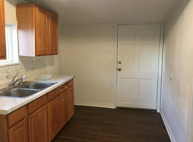 a kitchen with sink cabinets and wooden floor