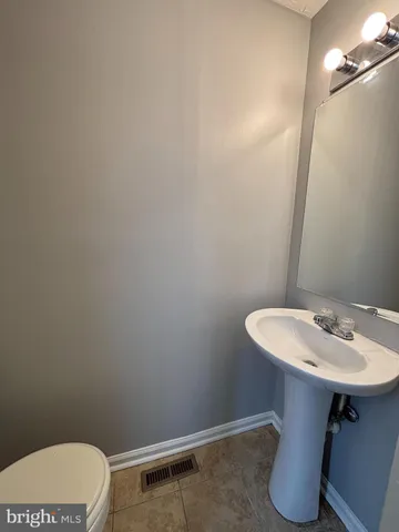 a bathroom with a sink toilet and a mirror