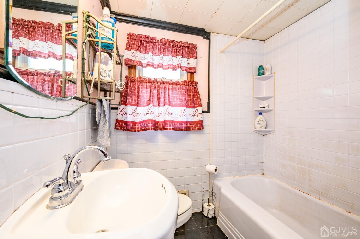 632 West Avenue Sewaren, NJ 07077 - Photo 16 of 30 a bathroom with a sink vanity mirror bathtub and toilet