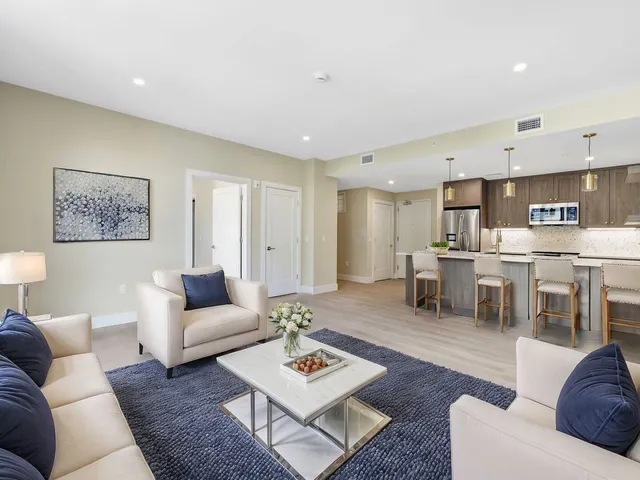 a living room with furniture and kitchen view