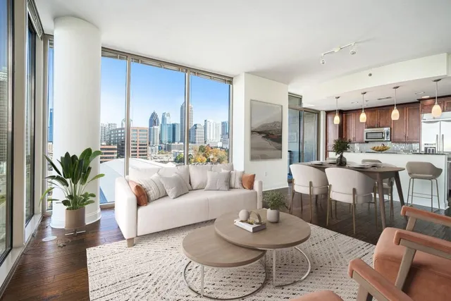 a living room with furniture kitchen and a large window