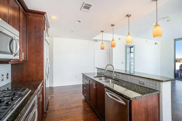 a kitchen that has a stove and a wooden floor
