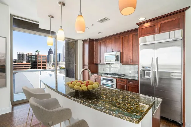 a kitchen with stainless steel appliances granite countertop a sink refrigerator and cabinets
