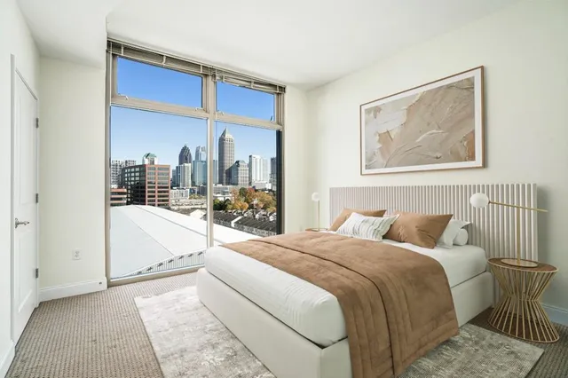 a bedroom with a large bed and a view of balcony