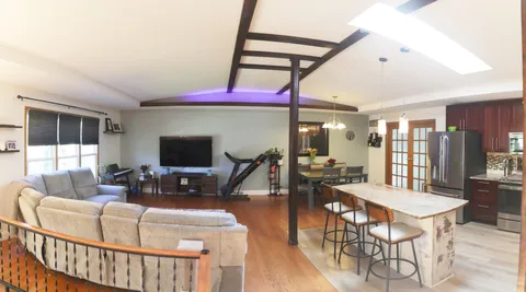 a living room with furniture a flat screen tv and a large window