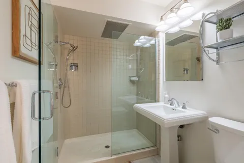 a bathroom with a bath tub sink mirror and a shower