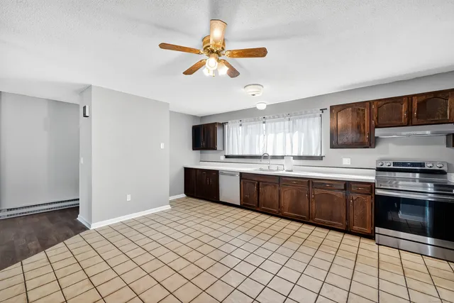 a kitchen with stainless steel appliances a sink cabinets and wooden floor