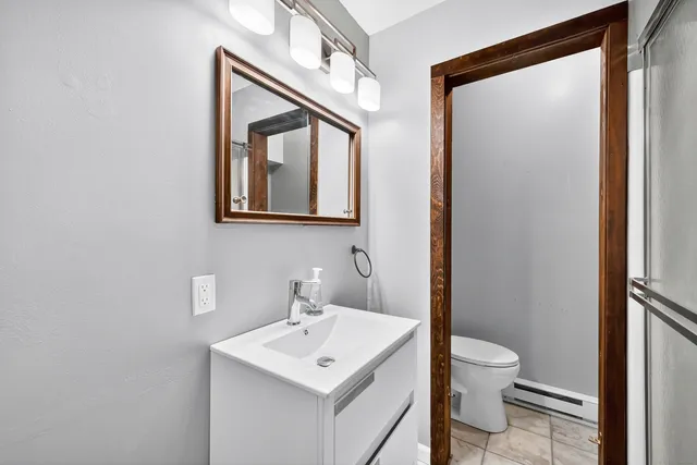 a bathroom with a toilet a sink and mirror