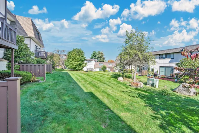 a view of a house with a big yard and potted plants