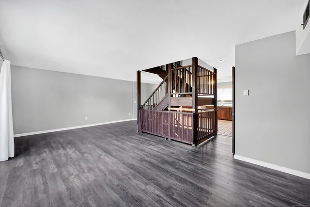 a view of a livingroom with wooden floor and stairs