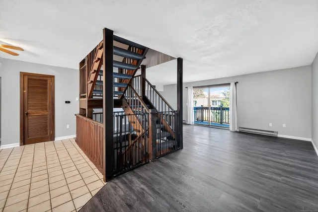 a view of a hallway with wooden floor and stairs