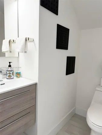 a bathroom with a toilet a sink and mirror