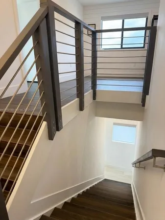 a view of a room with wooden floor and windows