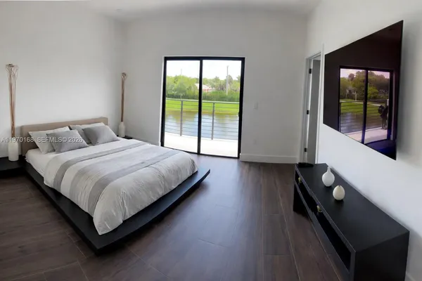 a large bed sitting in a bedroom next to a window